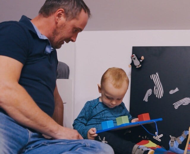 Kristián engaging in a developmental activity with his father, using colored blocks to enhance his visual and cognitive skills-1